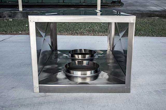 New Stainless steel chimney chase cover and cap sitting on ground before install