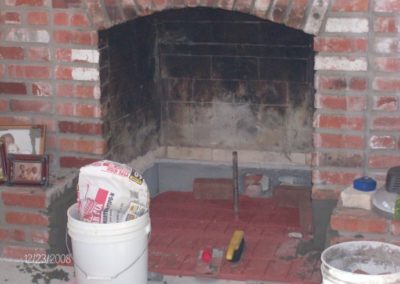 Fireplace Base Laying in progress with materials and tools in the foreground