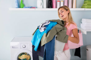 woman looking at clothes in her arms woman looking at clothes in her arms